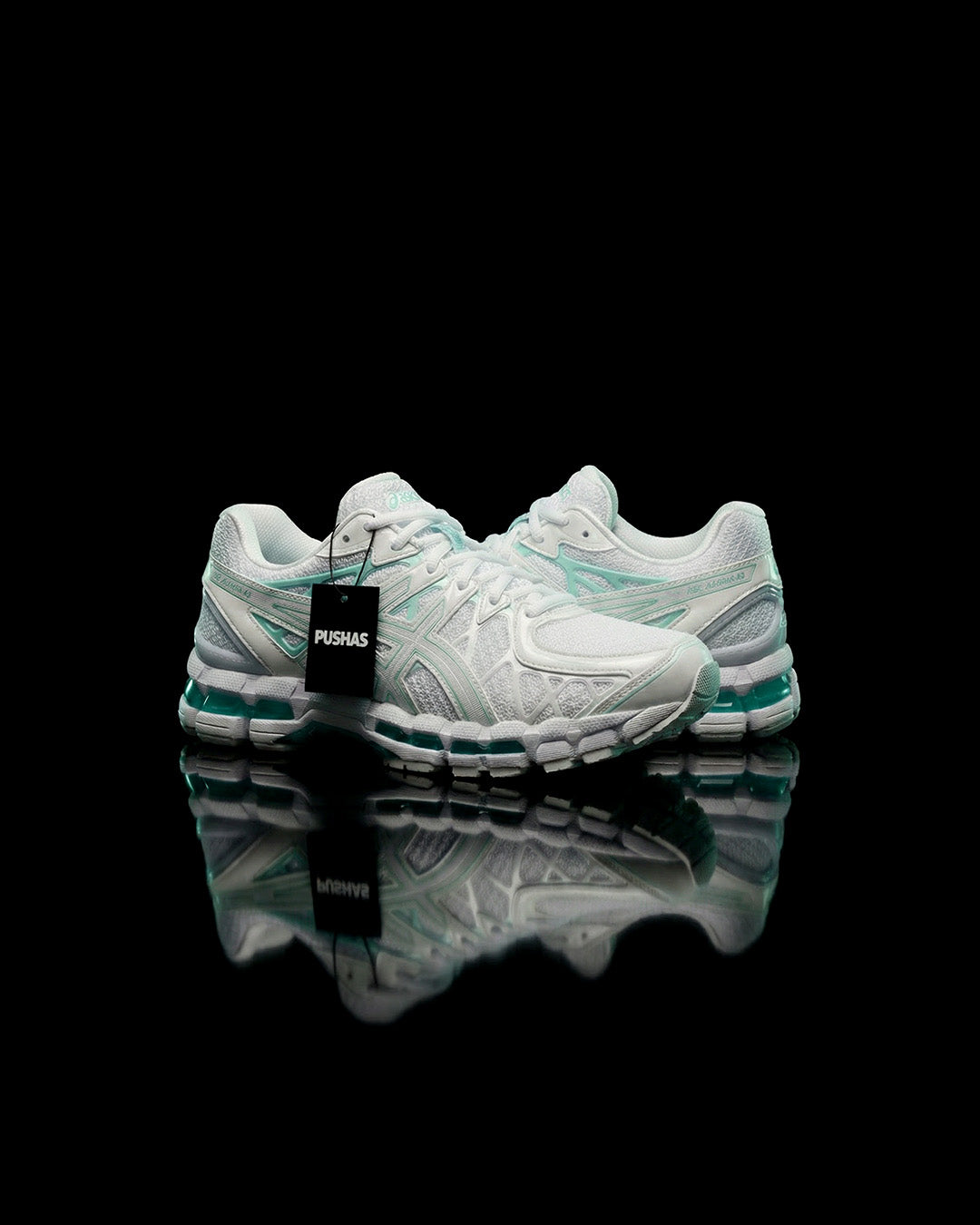 ASICS Gel-Kayano 20 'Illuminate Mint' (2026) white and mint runner on a black reflective surface with a PUSHAS tag